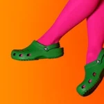 a pair of legs in pink tights and green crocs