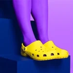 a person wearing purple tights and yellow crocs sandals